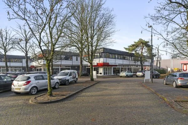 Bedrijfsverzamelgebouw aan de Huis-ter-Heideweg met geparkeerde auto's op een boomrijke parkeerplaats.